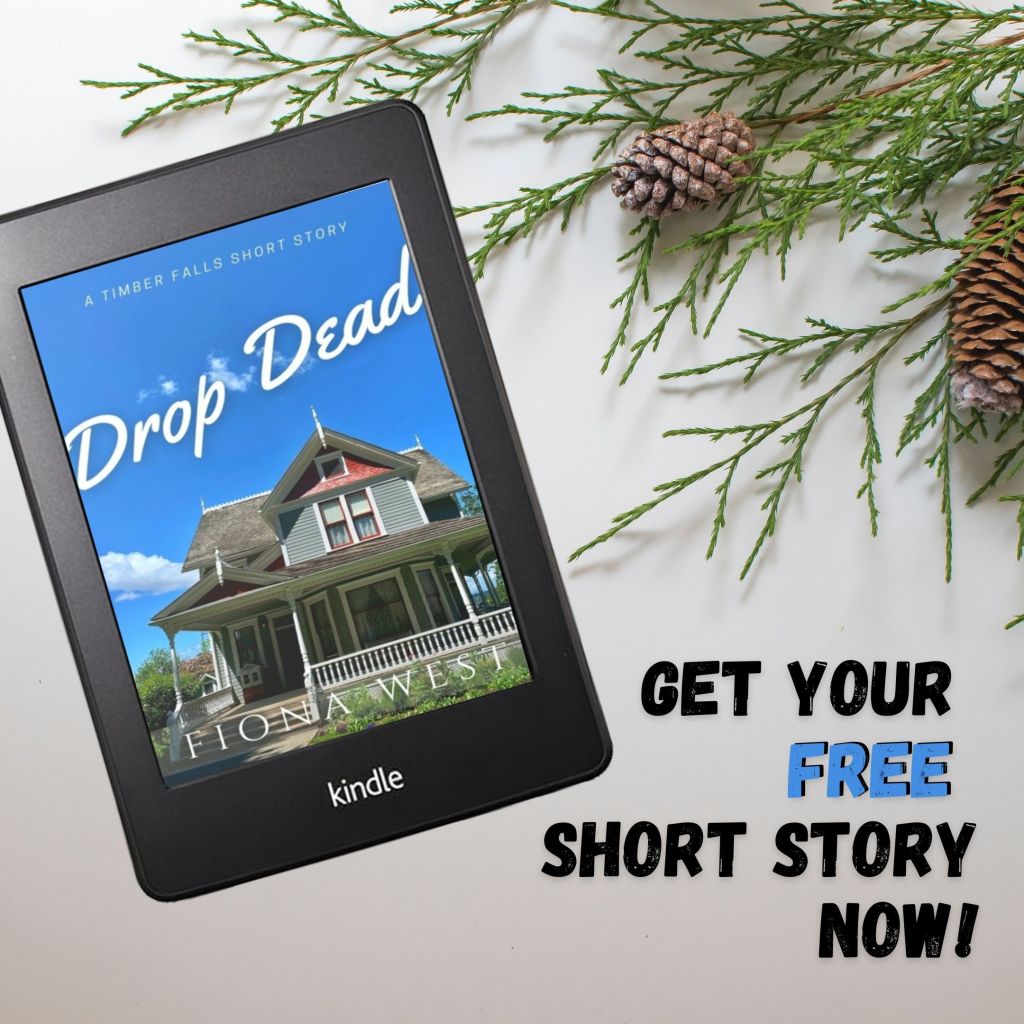 A blue Victorian house is set against a bright blue sky. The title reads "Drop Dead by Fiona West." There are pine branches around the Kindle. 